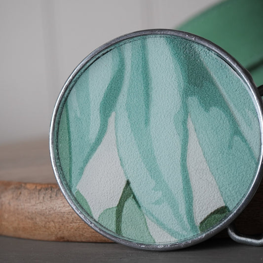 Round green and white patterned object on a wooden surface with a blurred background